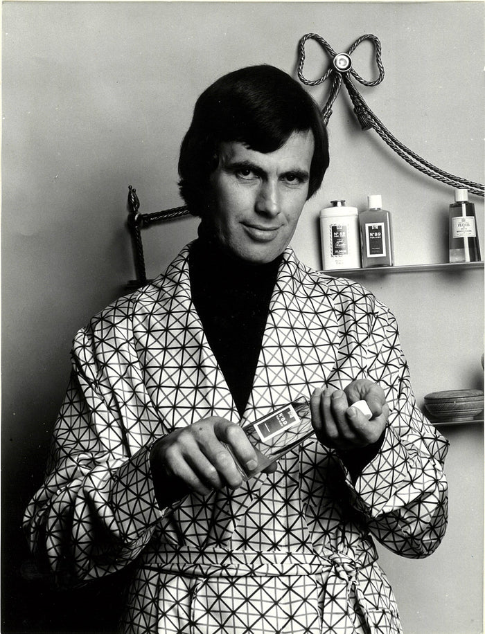 A man holding a bottle of perfume 