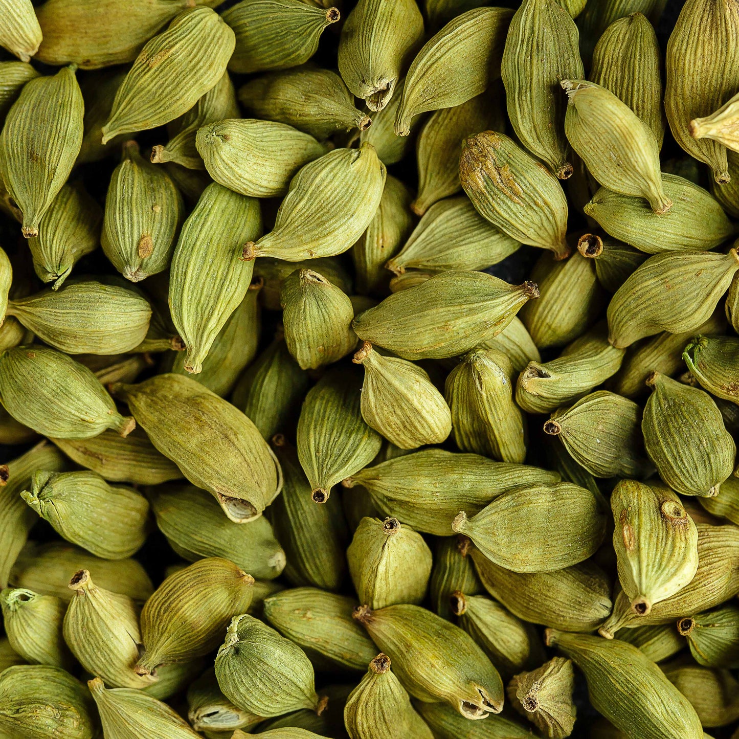 Close-up of whole green cardamom pods, whose citrusy scent inspires Floris London Cefiro Eau de Toilette—a unique unisex fragrance.