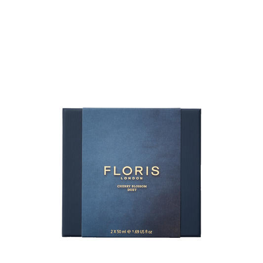 Floris London's "Cherry Blossom Duet" gift set in dark blue features two 50ml bottles, exuding refined intensity against a plain background.