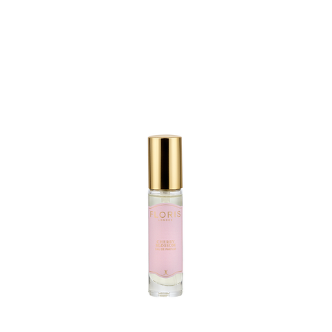 A small glass perfume bottle with a gold cap and pink label reading "Cherry Blossom - Eau de Parfum" by Floris London evokes Hanami’s floral-fruity scent.