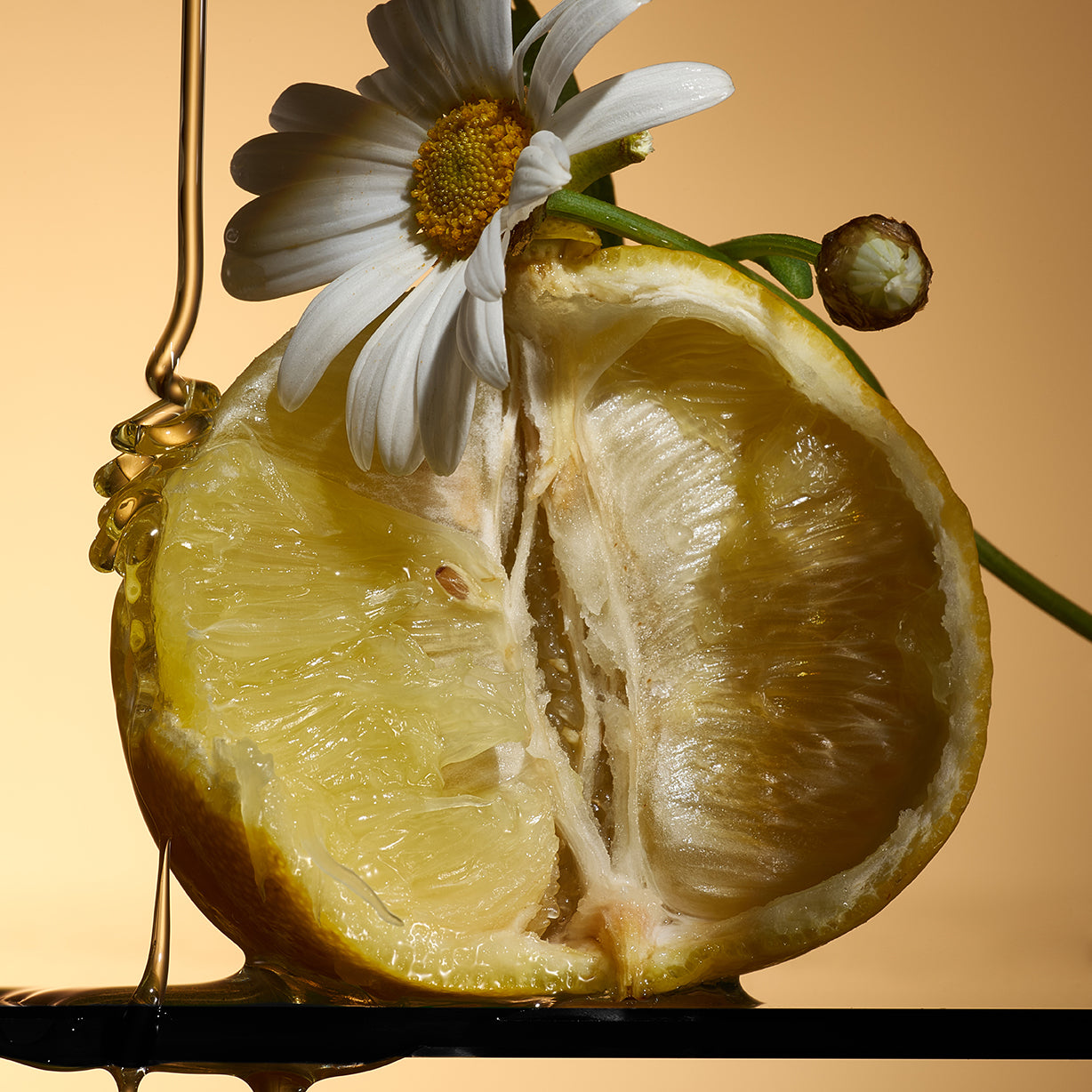 A halved lemon with a chamomile flower and honey drizzle evoke Celest - Eau de Parfum by Floris London UK, set against a warm background.