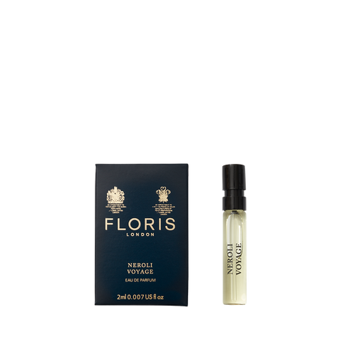 A perfume sample bottle sits next to a navy Floris London box labeled "Neroli Voyage - Eau de Parfum," exuding the scent of neroli and warm amber.