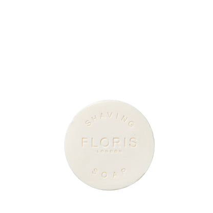 Round white No. 89 Shaving Soap Refill by Floris London, embossed with the brand name, features sandalwood and shea butter, on a white background.