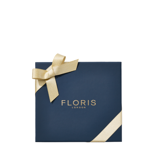 Navy gift box labeled "Floris London" with gold ribbon, ideal for the festive season, featuring the "Perfumer's Trilogy: For Him" British fragrances.